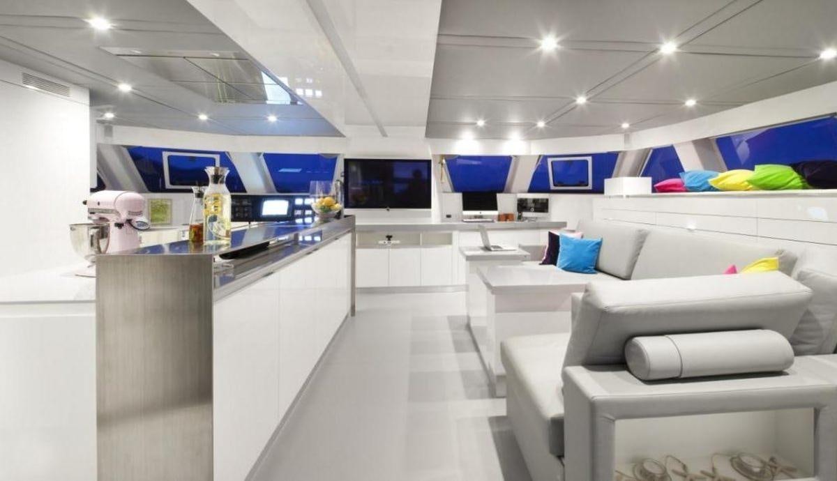 a room with white couches and a counter with a blue screen aboard MAVERICK Yacht for Charter