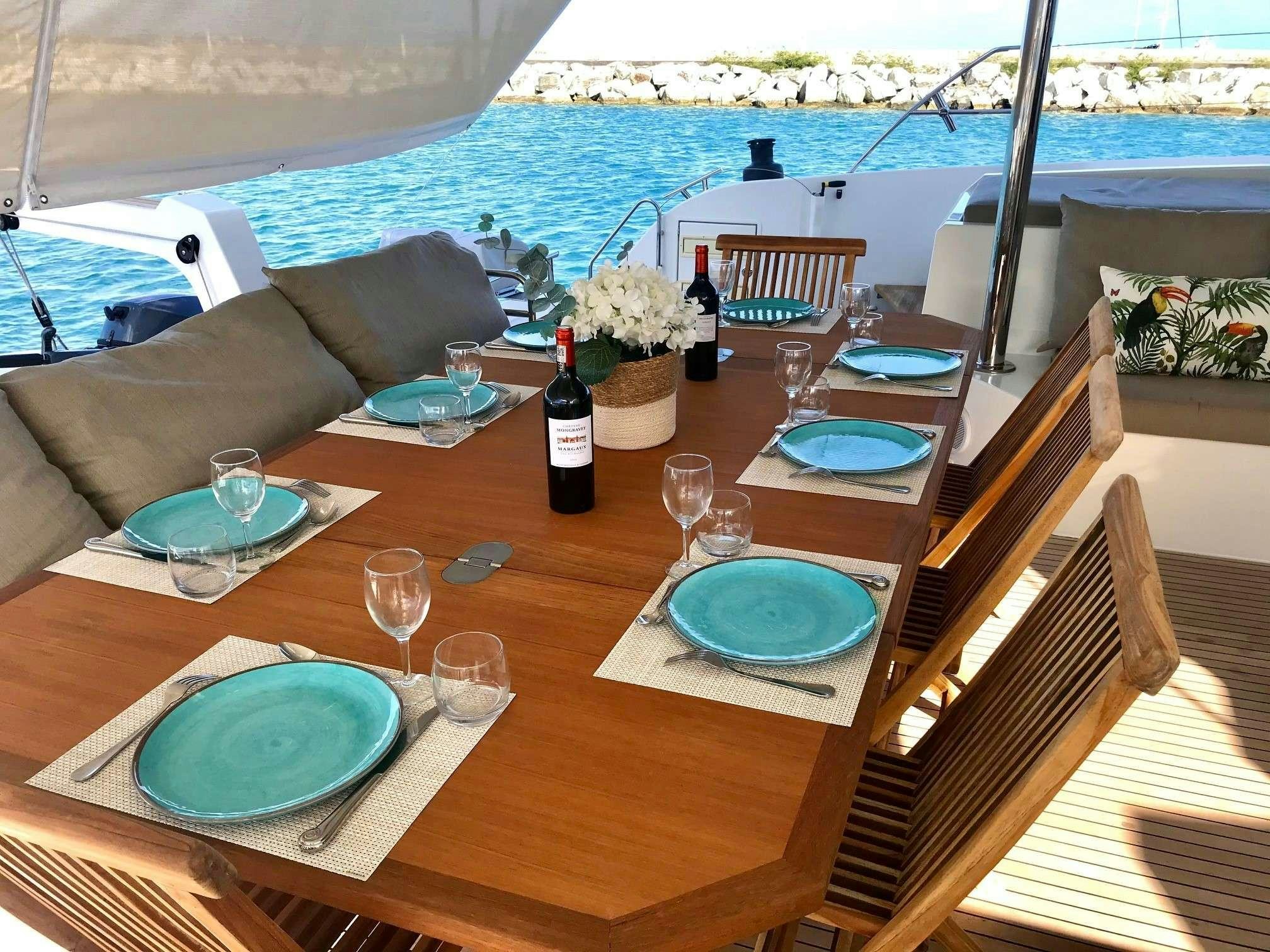 a table with wine glasses and bottles on it aboard ENCHANTE Yacht for Charter