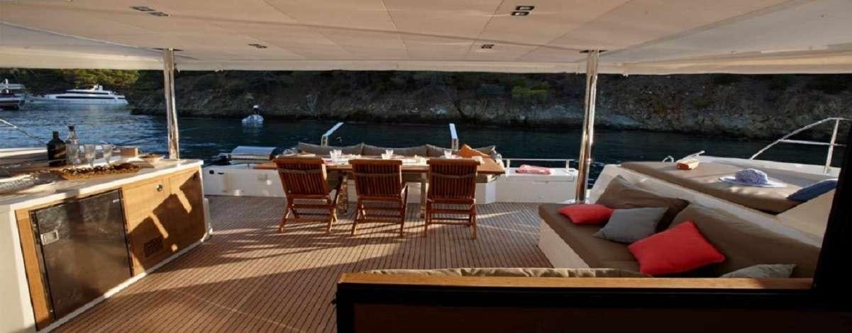 a room with a deck and chairs aboard ENCHANTE Yacht for Charter