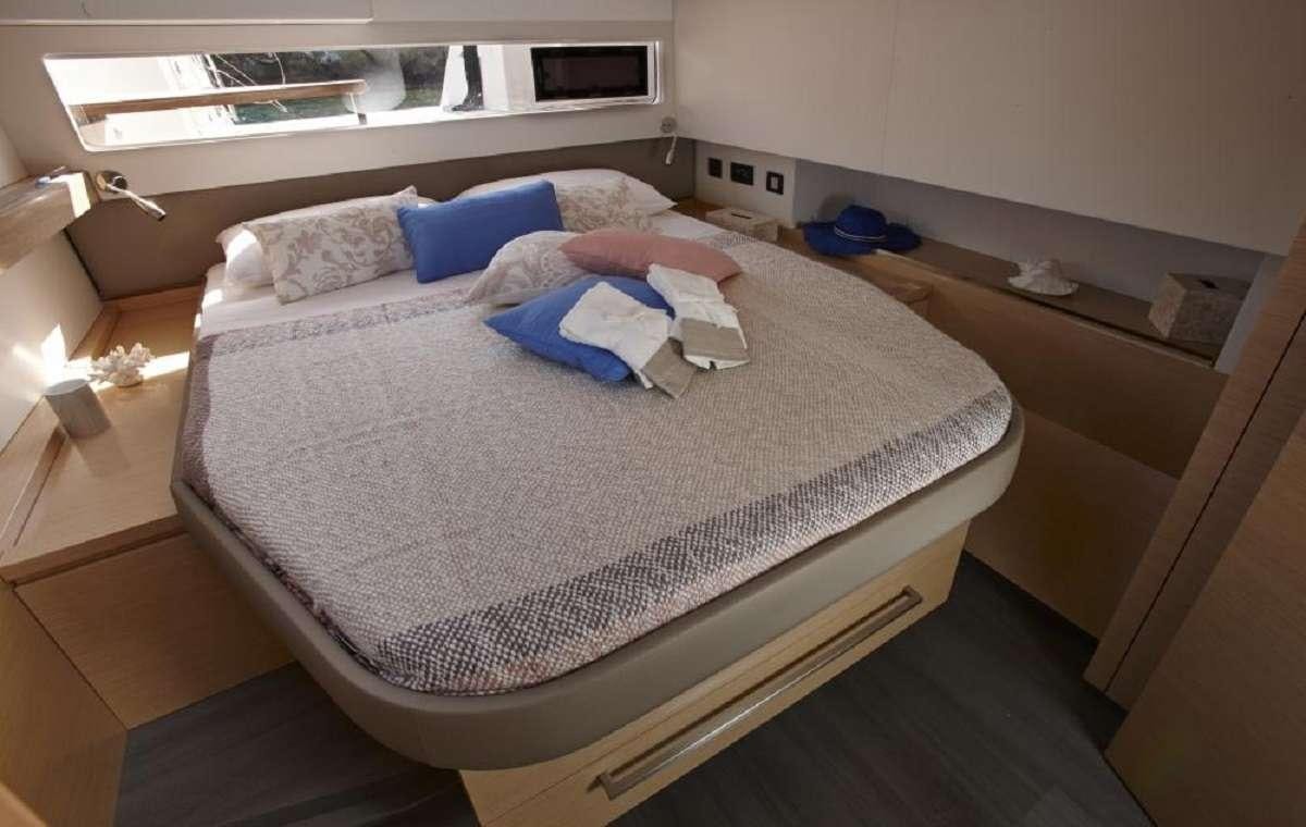 a bed with a blue pillow aboard ENCHANTE Yacht for Charter