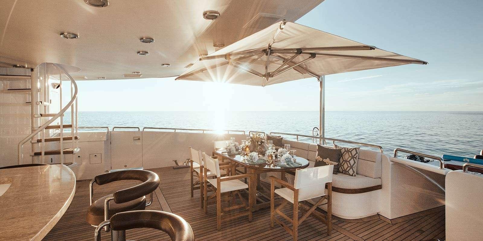 a large white tent with chairs and tables on a deck aboard ENTOURAGE Yacht for Charter