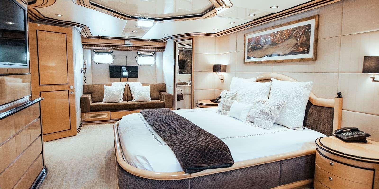 a hotel room with a bed and a couch aboard ENTOURAGE Yacht for Charter