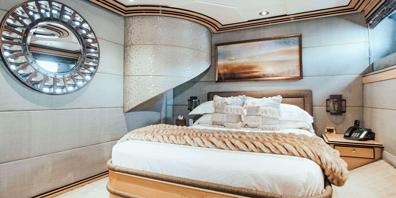 a bed with a round mirror above it aboard ENTOURAGE Yacht for Charter