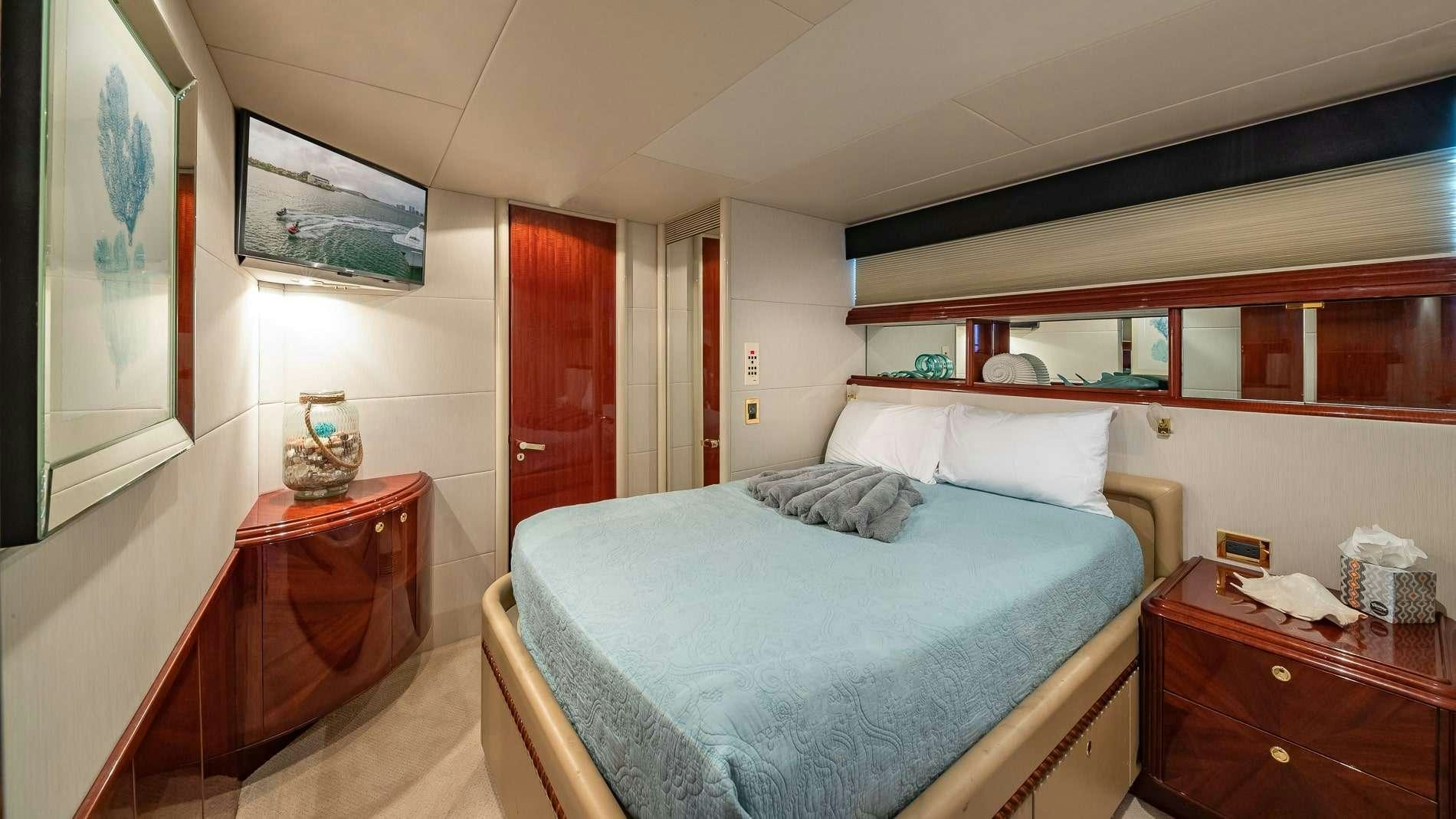 a bedroom with a bed and a dresser aboard IV TRANQUILITY Yacht for Charter