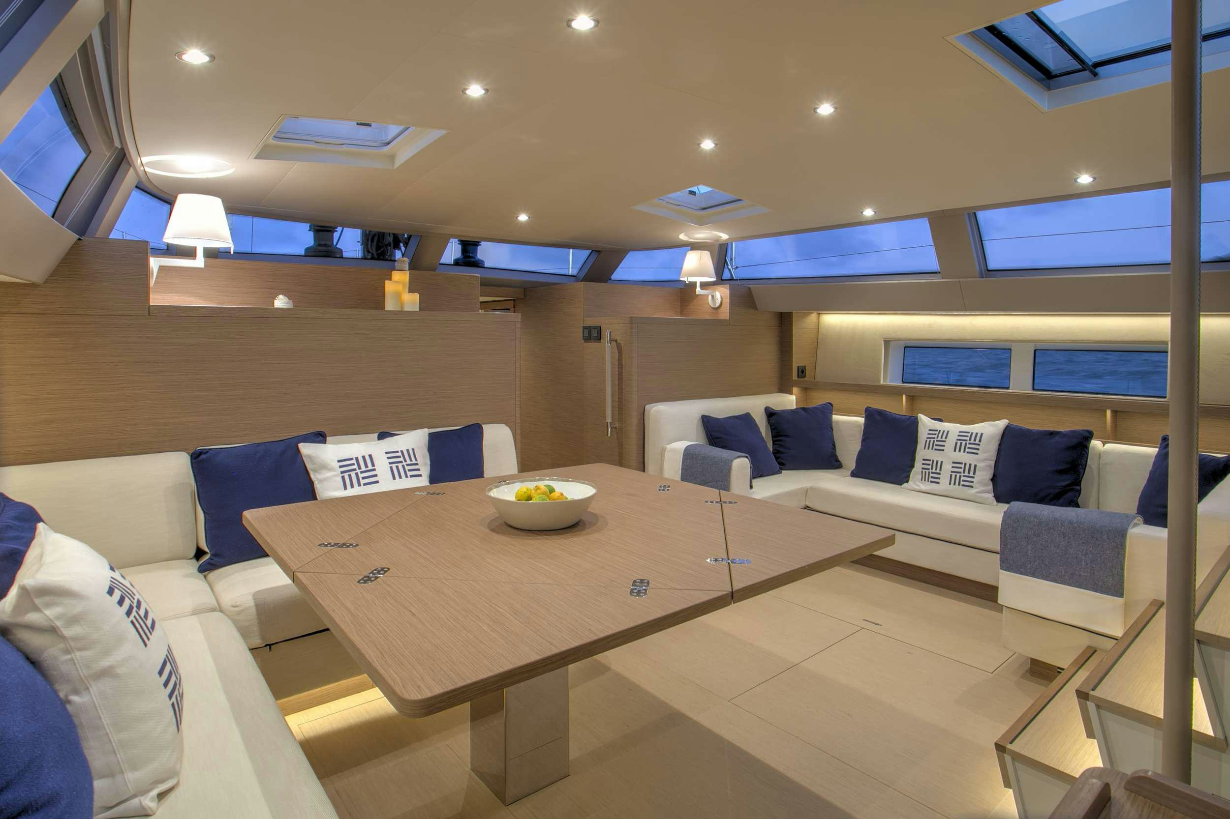 a room with a table and couches aboard CNB66 Yacht for Charter