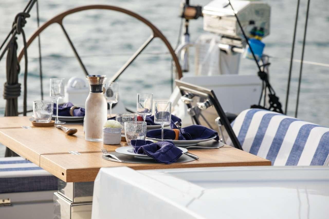 a table with a set of glasses and a white tablecloth aboard CNB66 Yacht for Charter