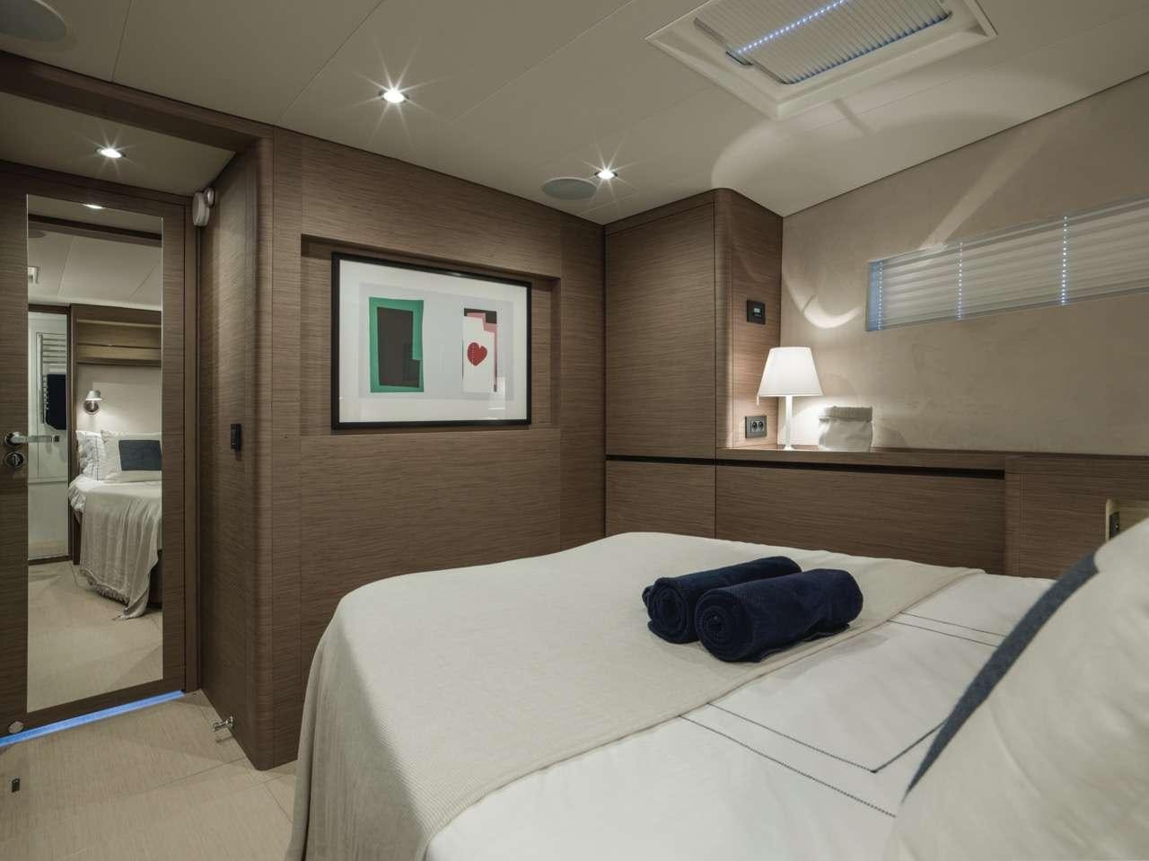 a bedroom with a bed and a mirror aboard CNB66 Yacht for Charter