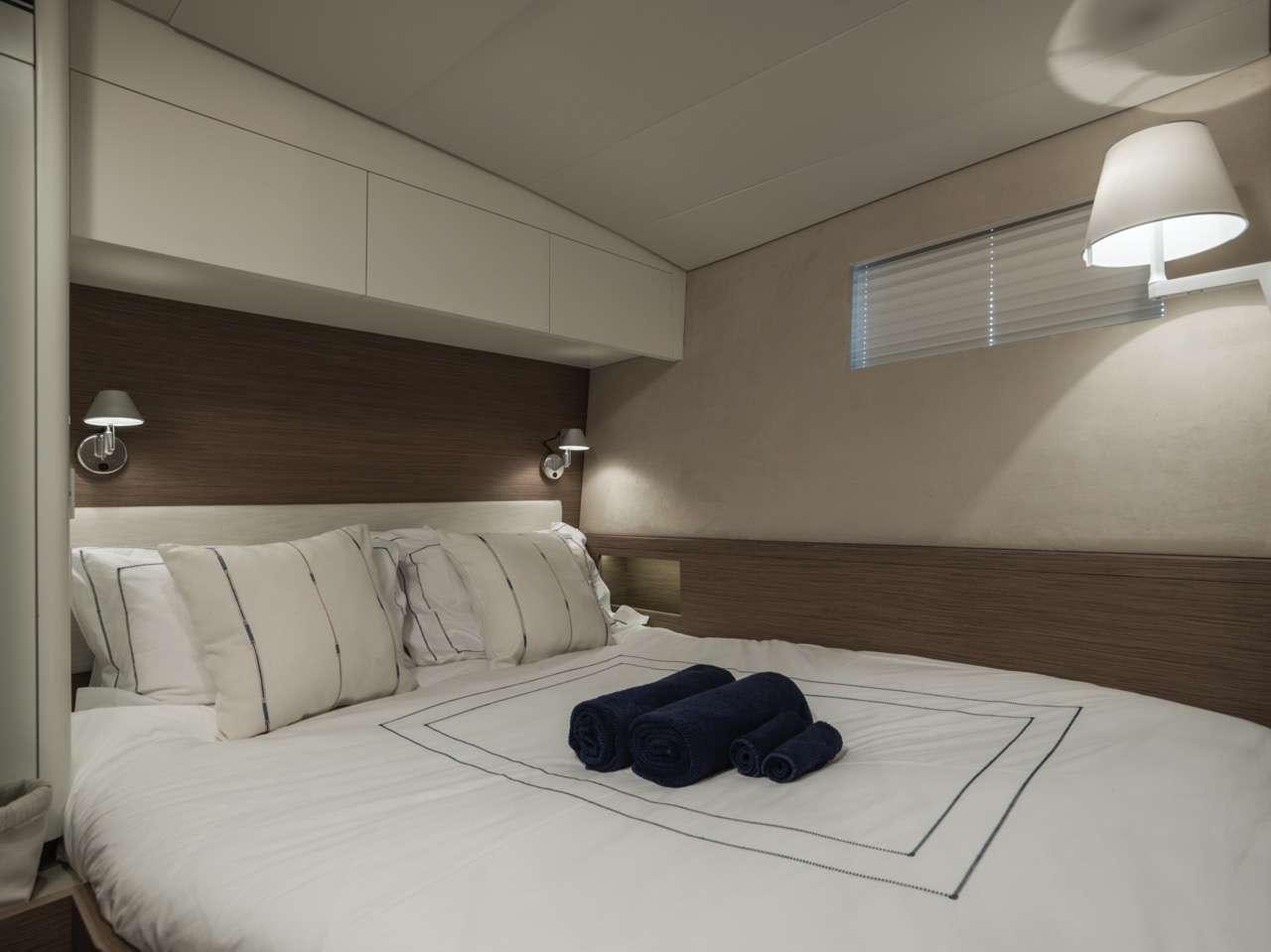 a bed with a blue blanket on it aboard CNB66 Yacht for Charter