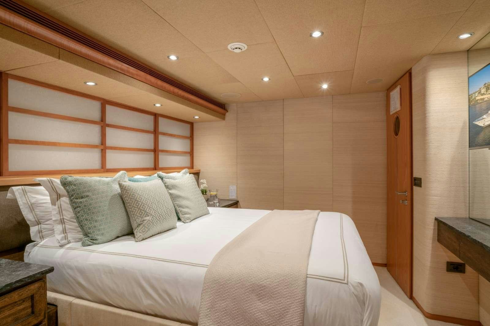 a room with a bed and a desk aboard ENVY Yacht for Charter