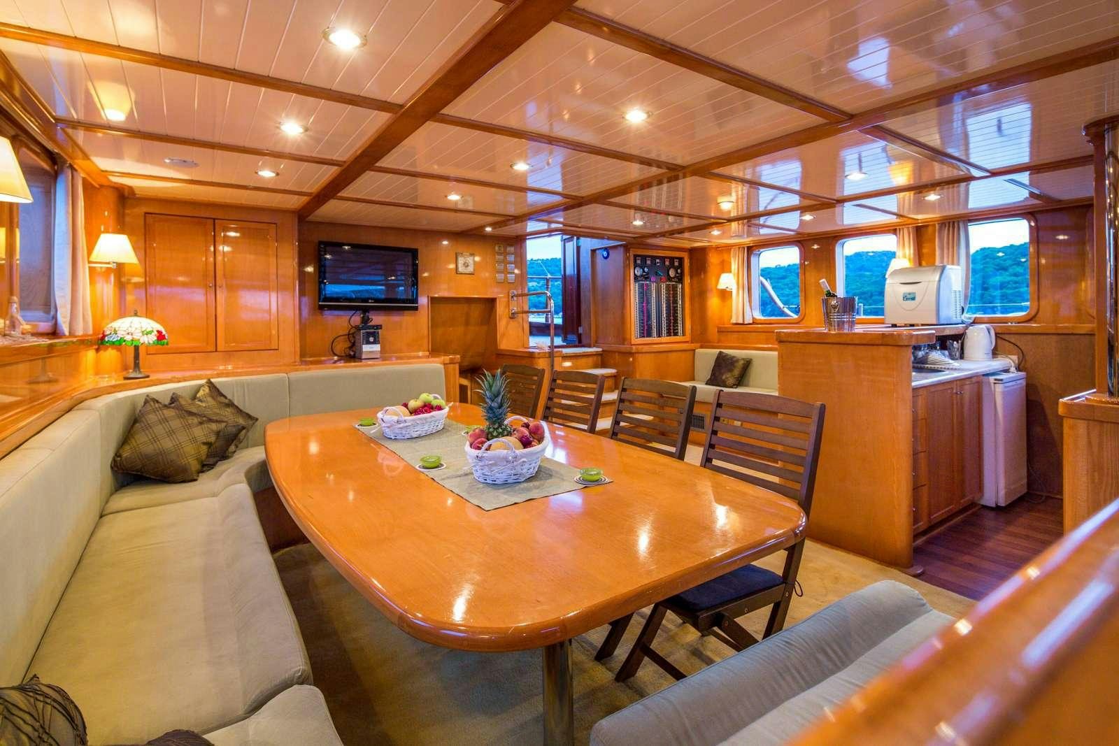 a living room with a table and chairs aboard morning star Yacht for Charter