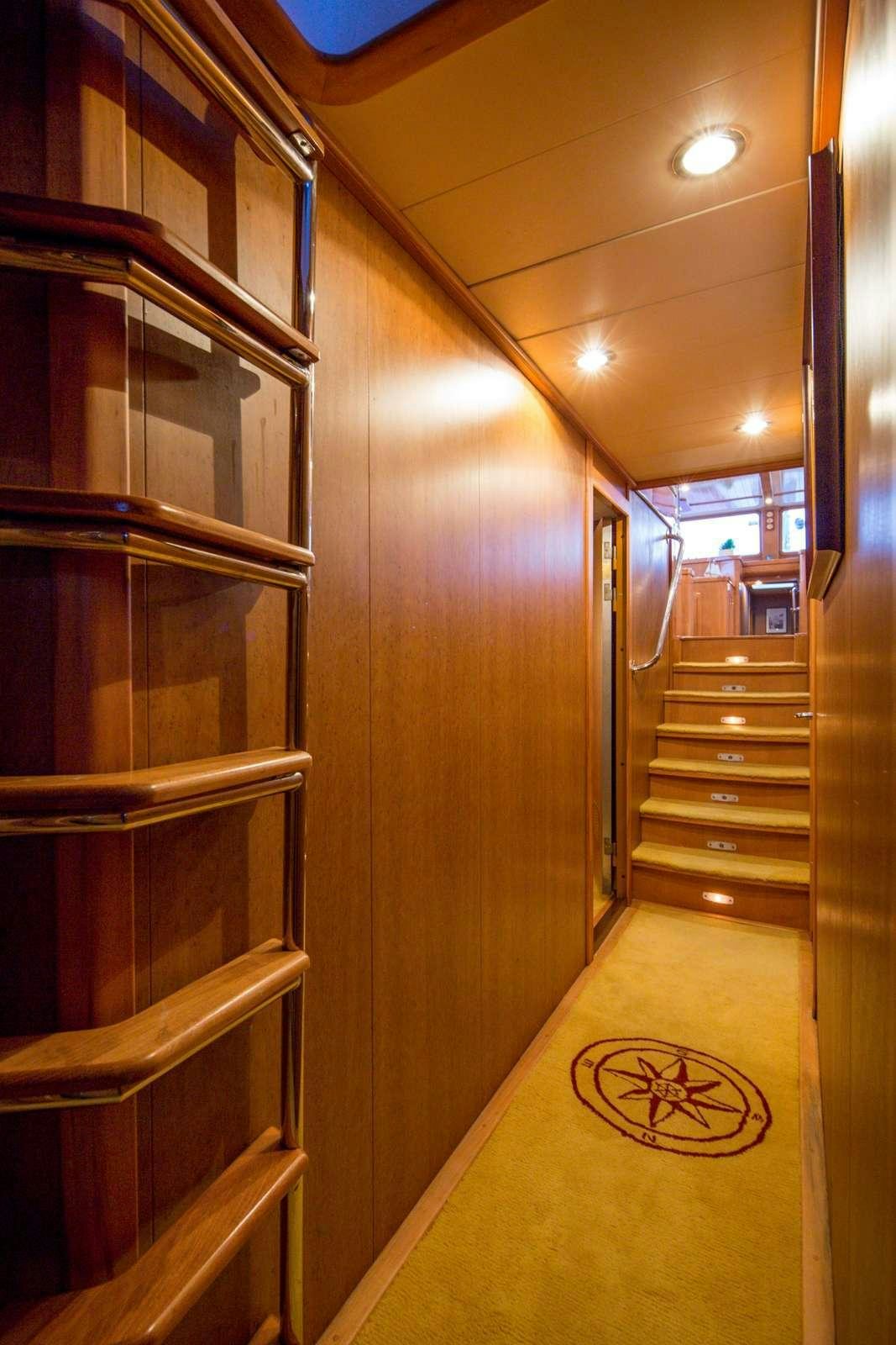 a hallway with a wood door and a rug on the floor aboard morning star Yacht for Charter