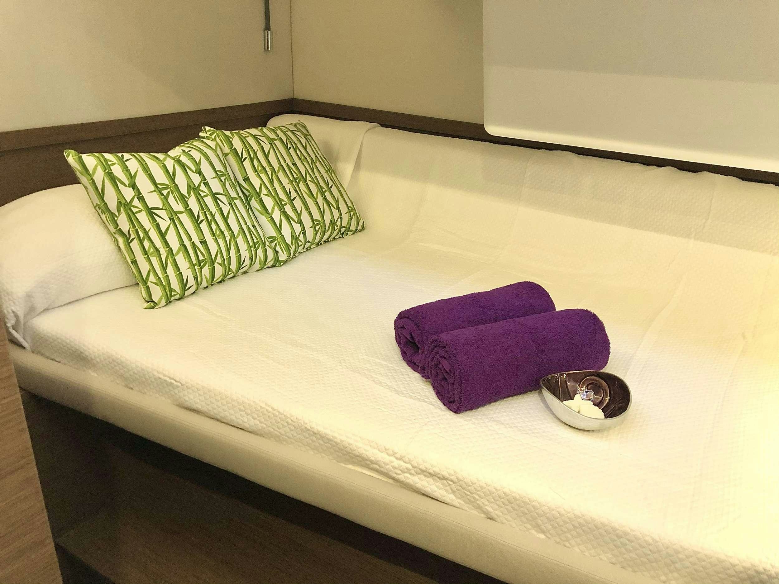 a pair of sunglasses on a bed aboard SEA IO Yacht for Charter