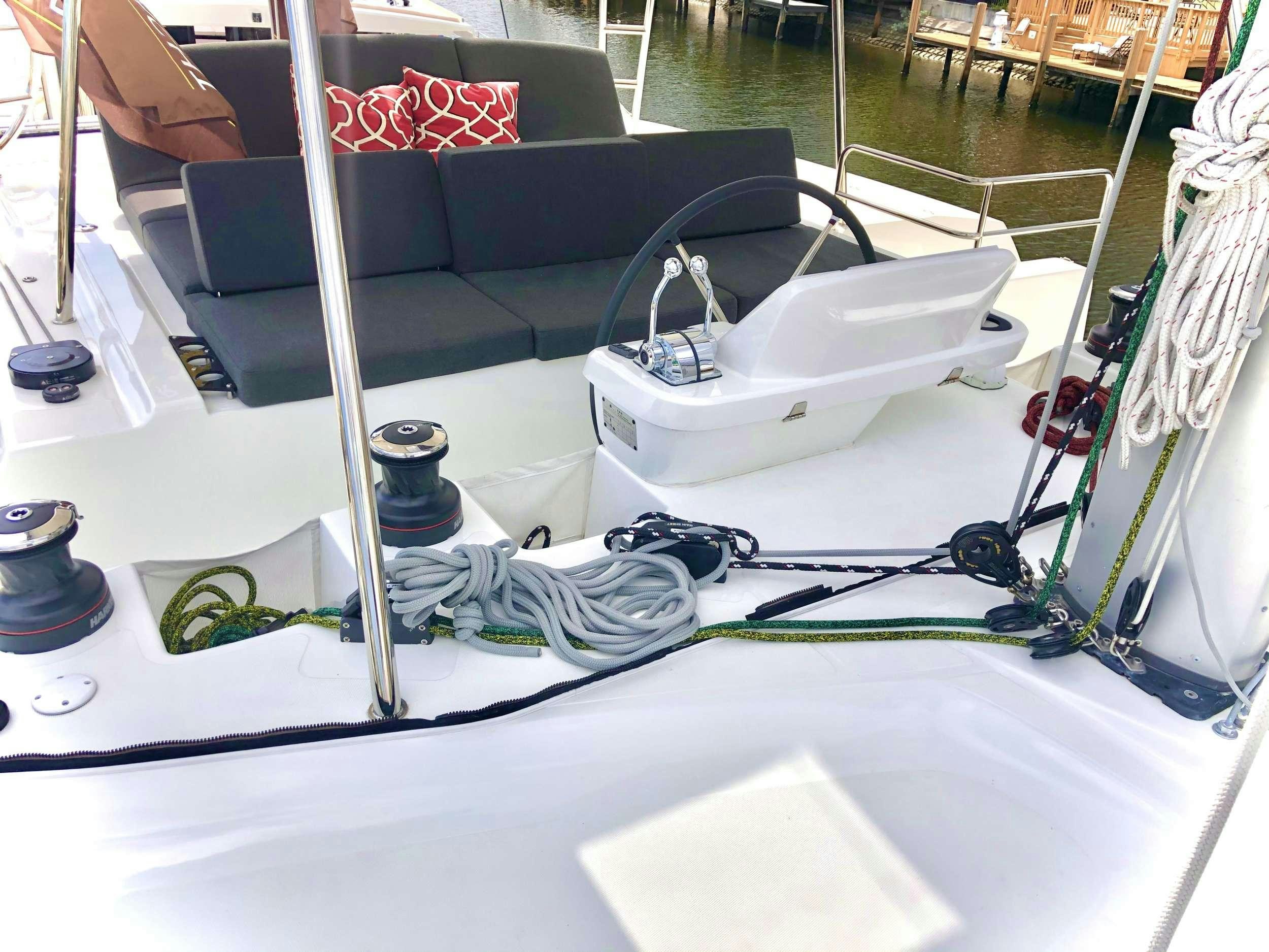 a white table with a black chair and a white table with a black and silver object on it aboard SEA IO Yacht for Charter