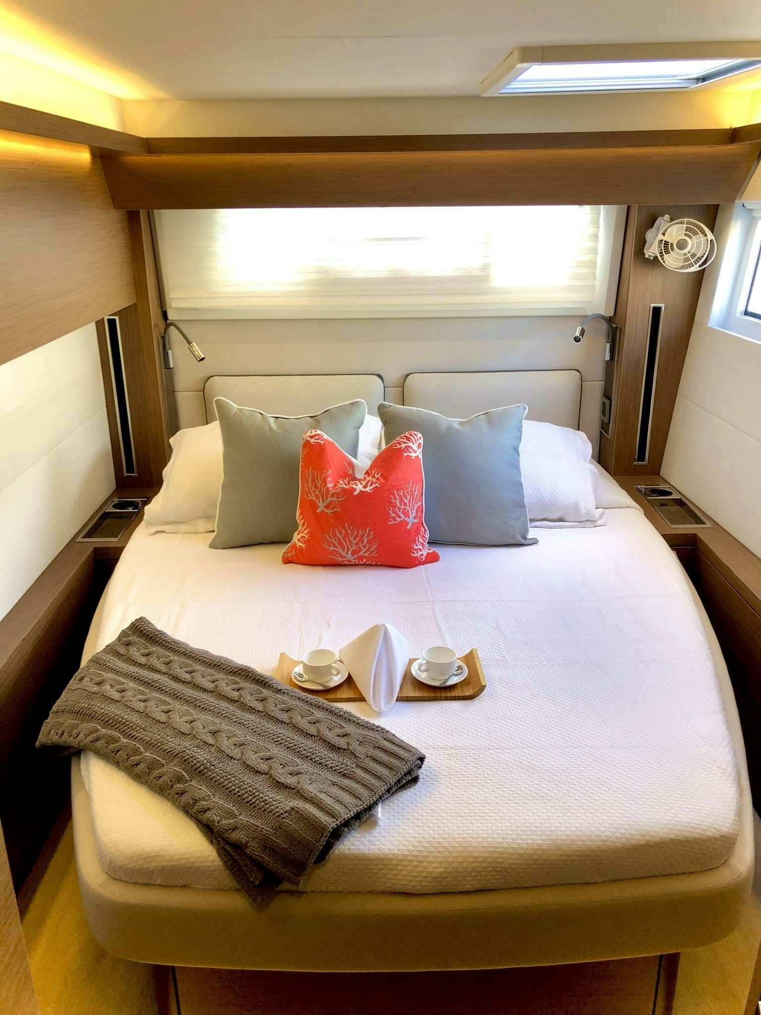 a bed with a table and chairs aboard SEA IO Yacht for Charter