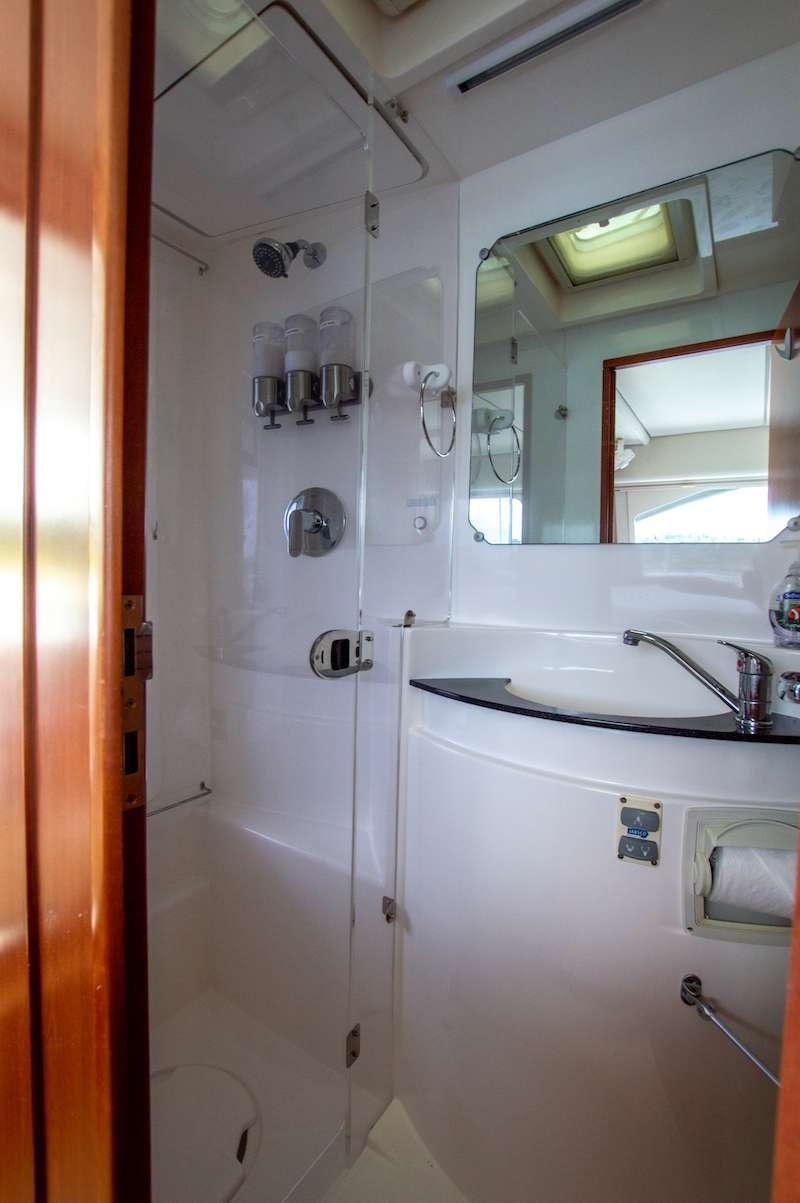 a shower with a sink and mirror aboard DOLPHIN DAZE Yacht for Charter