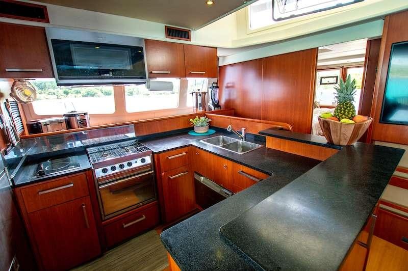 a kitchen with wooden cabinets aboard DOLPHIN DAZE Yacht for Charter