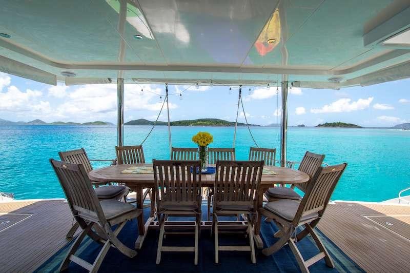 a table set for a meal on a deck overlooking the ocean aboard DOLPHIN DAZE Yacht for Charter
