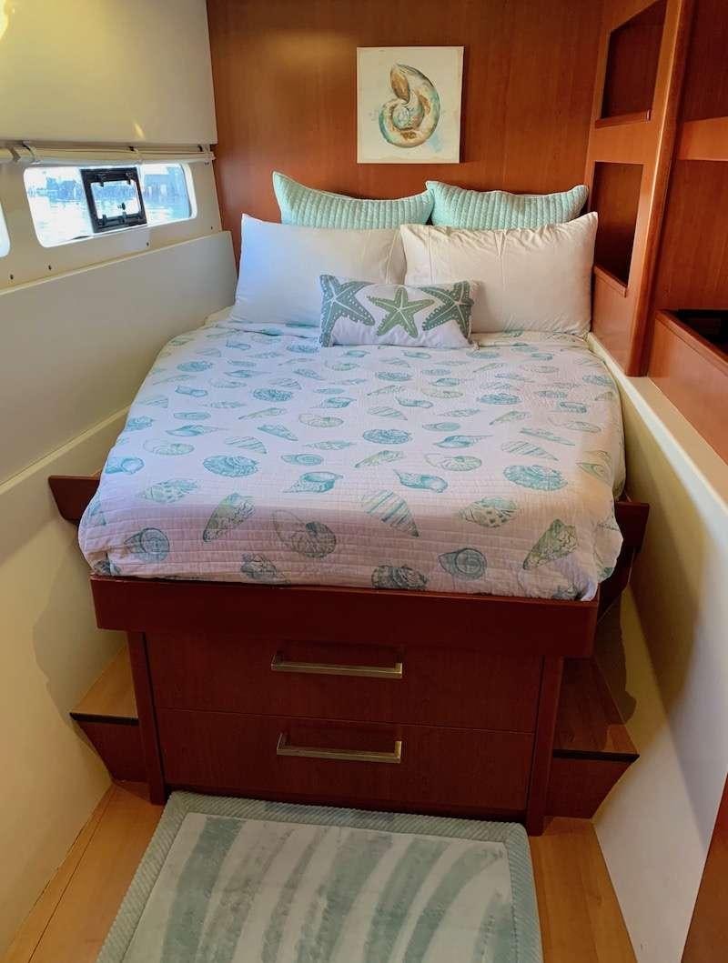a bed with a white comforter aboard DOLPHIN DAZE Yacht for Charter