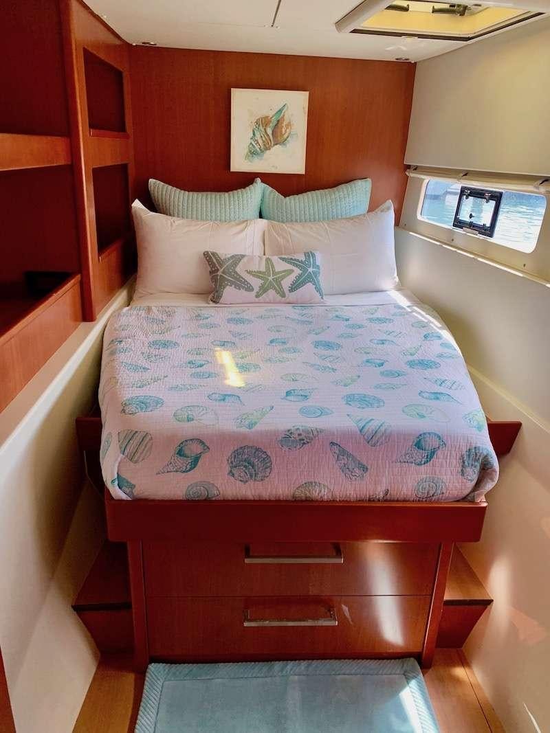 a bed with a blue and pink comforter and pillows aboard DOLPHIN DAZE Yacht for Charter