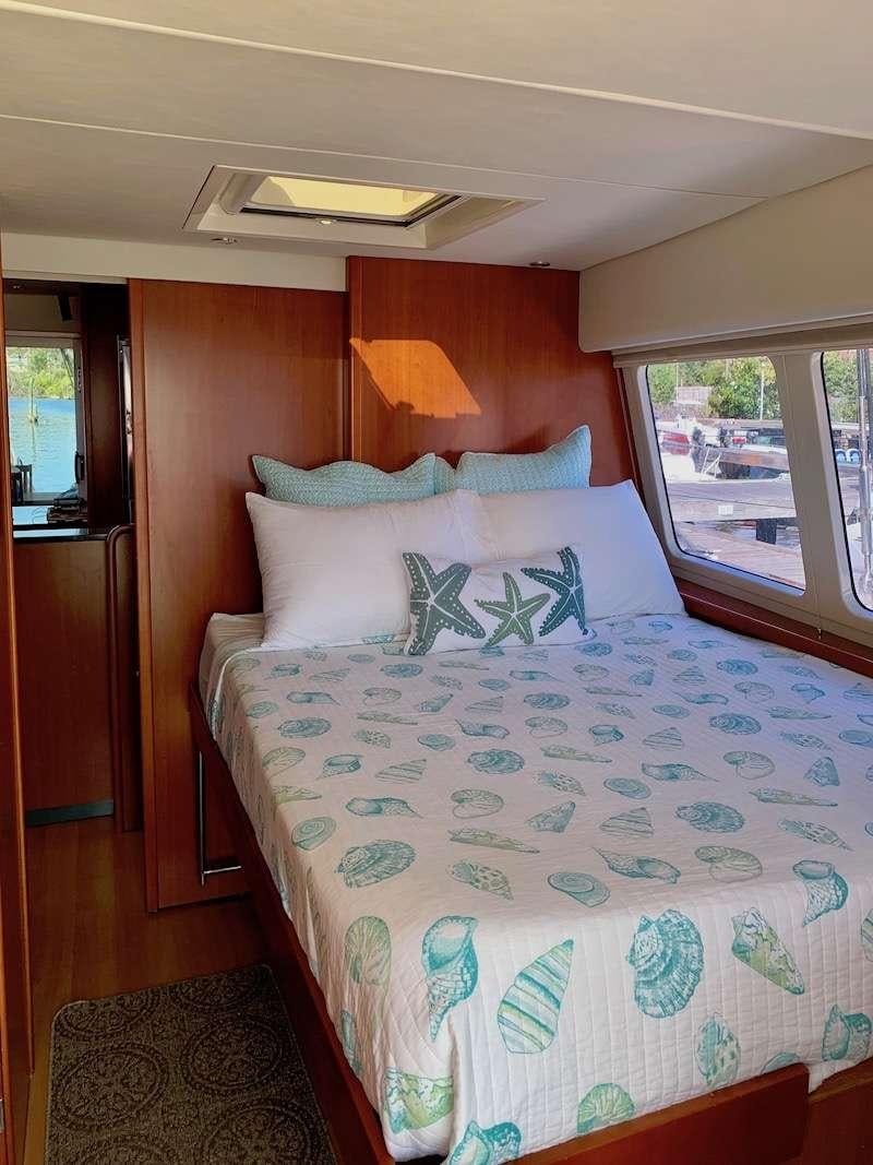 a bed with a blue comforter aboard DOLPHIN DAZE Yacht for Charter