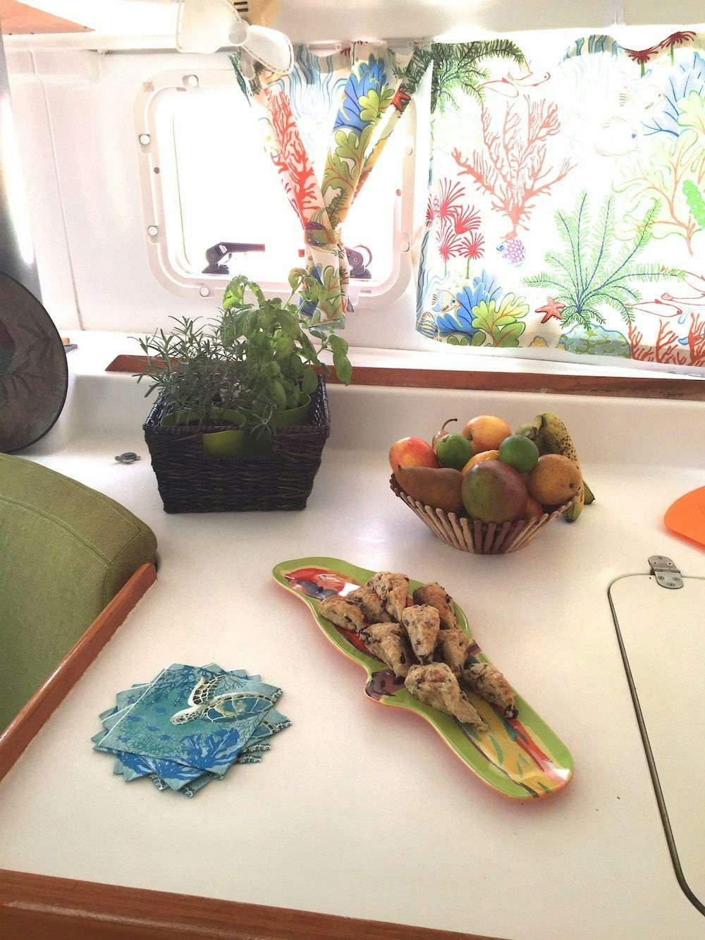 a table with a plate of food and a bowl of fruit aboard MANGO Yacht for Charter