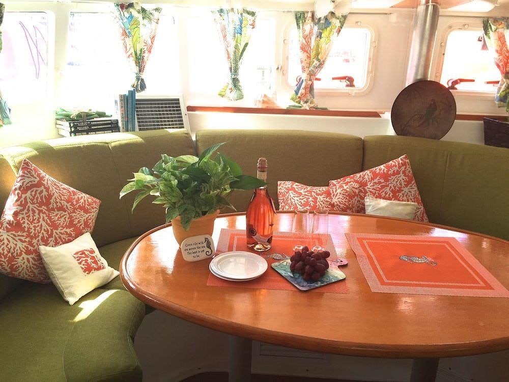 a table with plates and a bottle of wine on it aboard MANGO Yacht for Charter