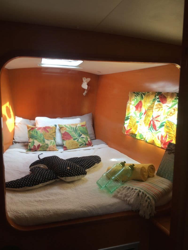 a bed with a colorful painting aboard MANGO Yacht for Charter