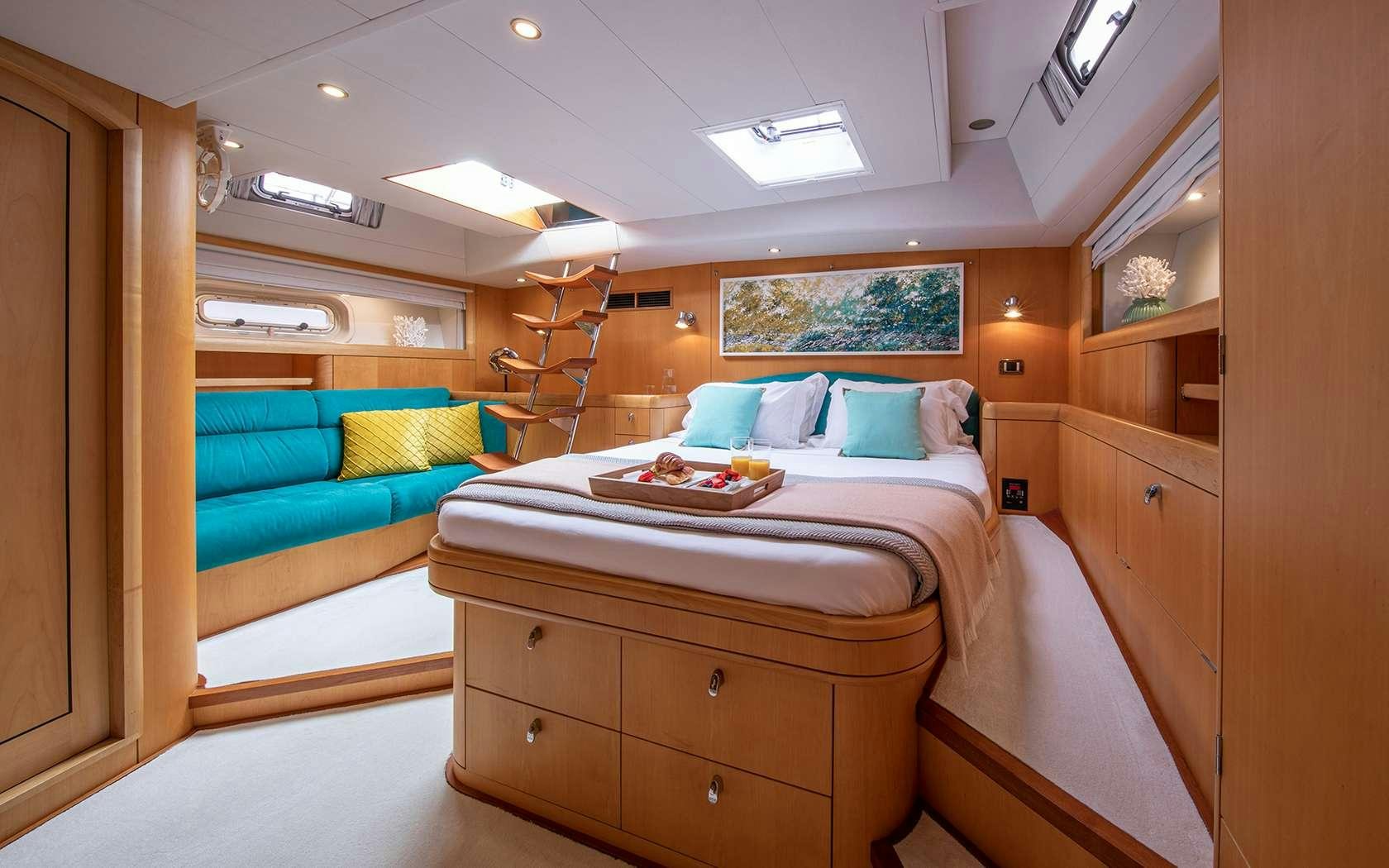 a room with a bed and a couch aboard BARE NECESSITIES Yacht for Charter