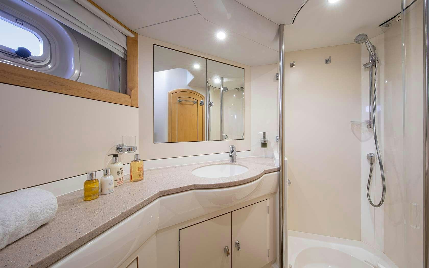 a bathroom with a shower and sink aboard BARE NECESSITIES Yacht for Charter