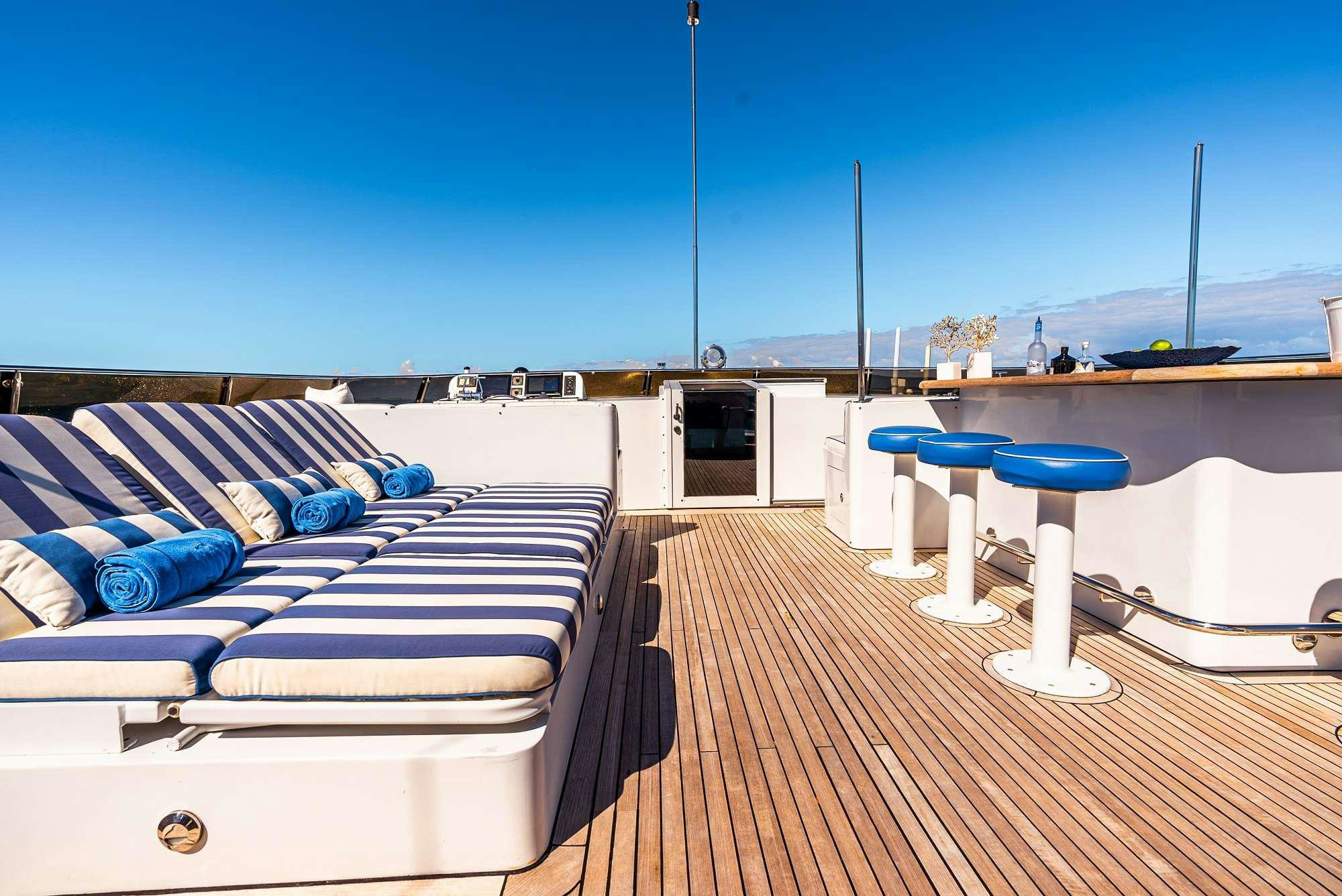 a deck with a couch and chairs aboard ODIN Yacht for Charter