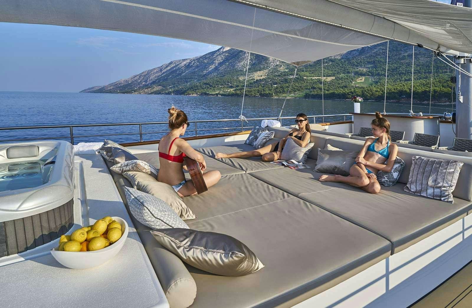 a group of people sitting on a lounge chair on a boat aboard DALMATINO Yacht for Charter
