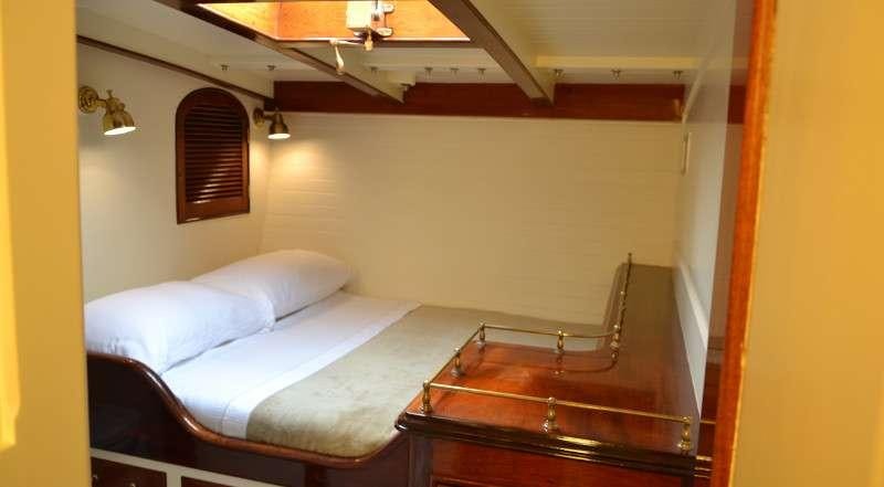 a bed with a wooden frame aboard WHITEFIN Yacht for Charter