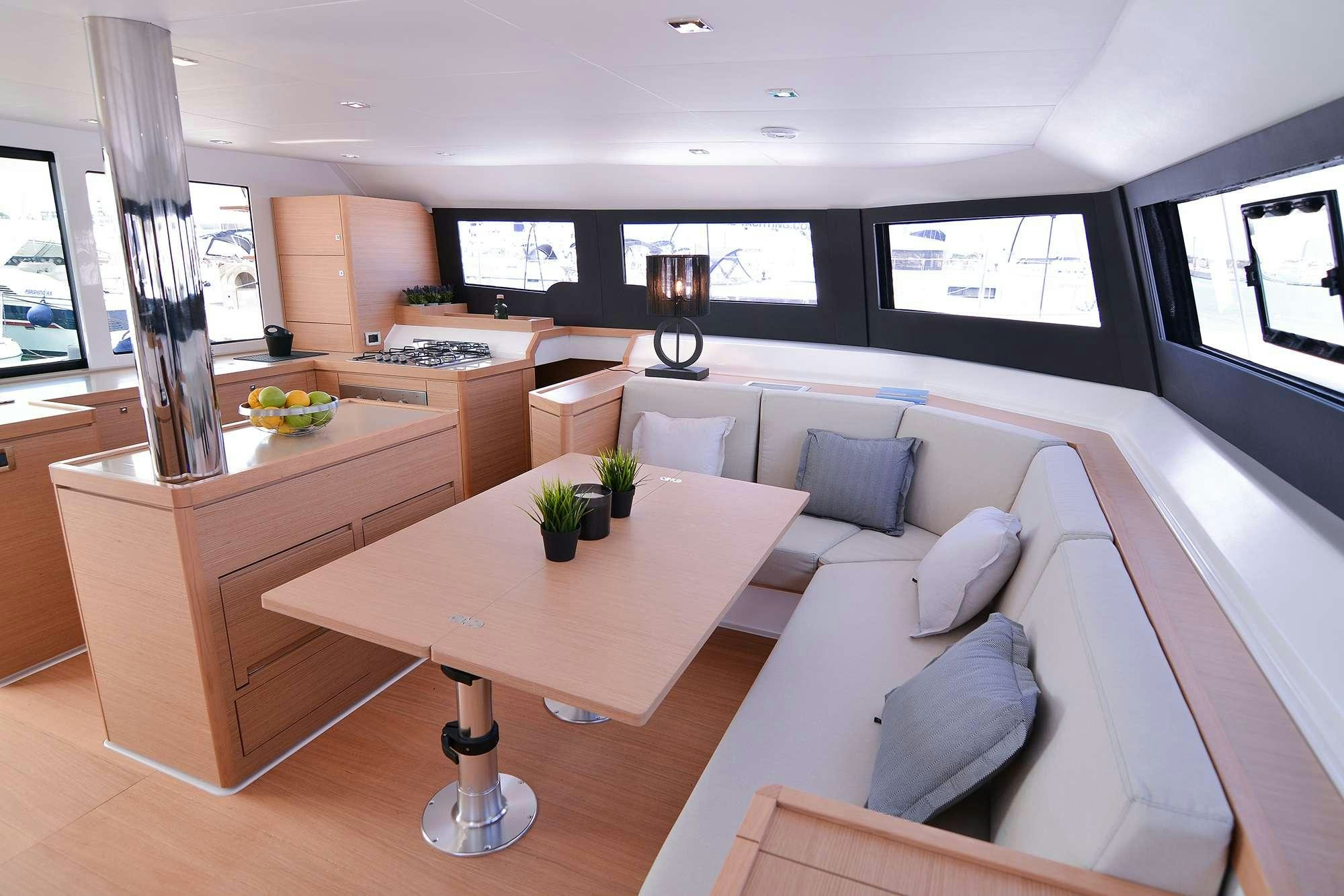 a room with a couch and a table with a lamp on it aboard NeuroSeas Yacht for Charter