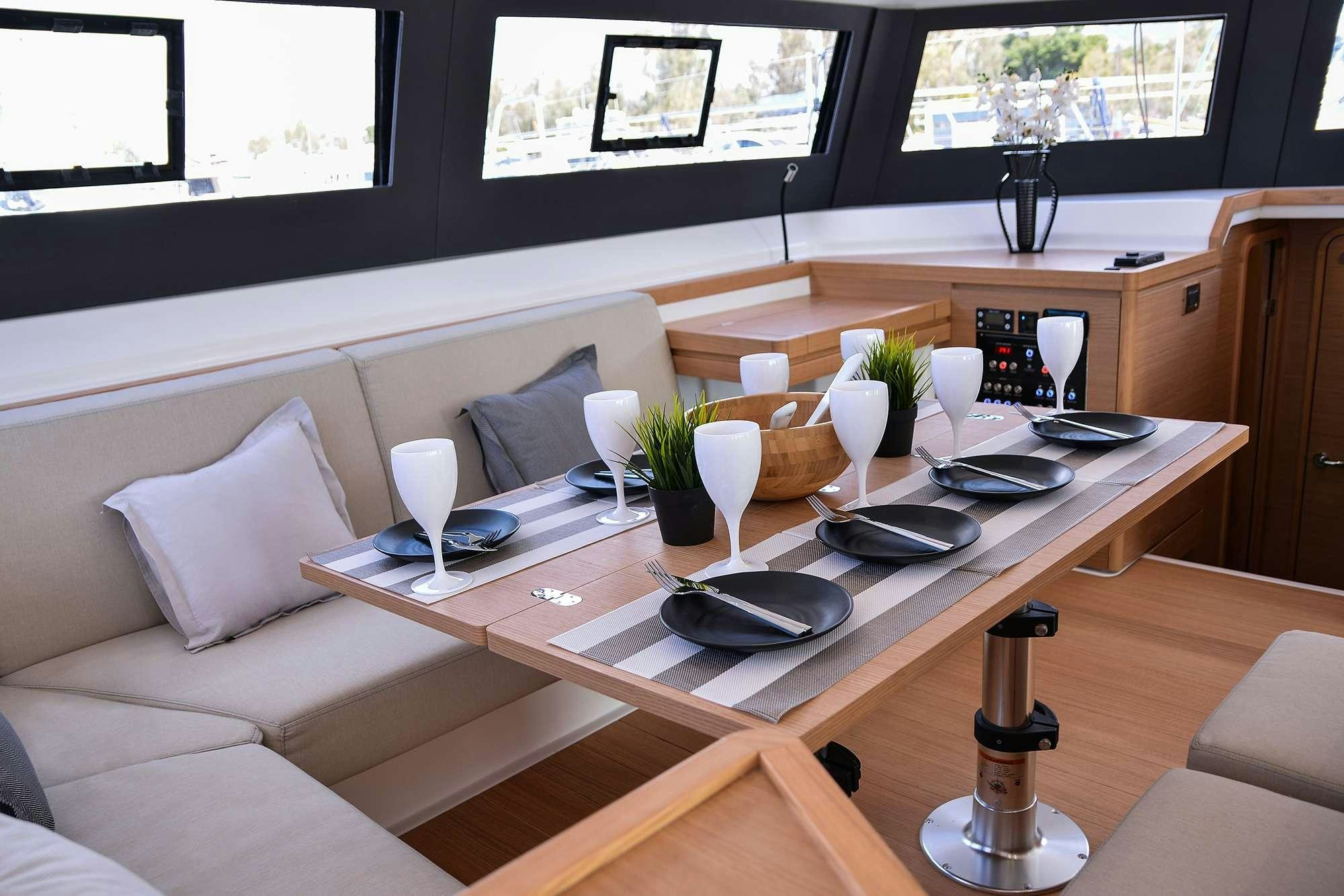 a table with a couch and chairs aboard NeuroSeas Yacht for Charter