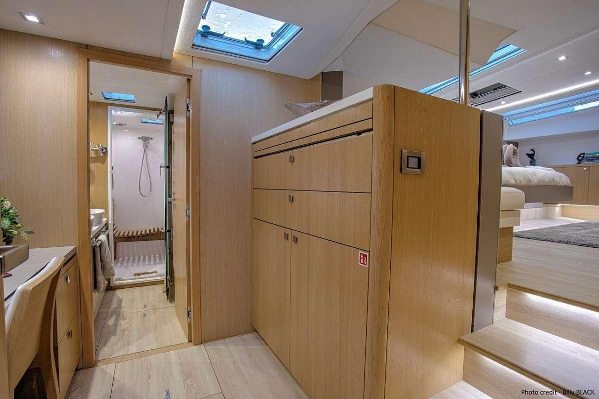 a room with a wood cabinet and a large mirror aboard NAMASTE Yacht for Charter