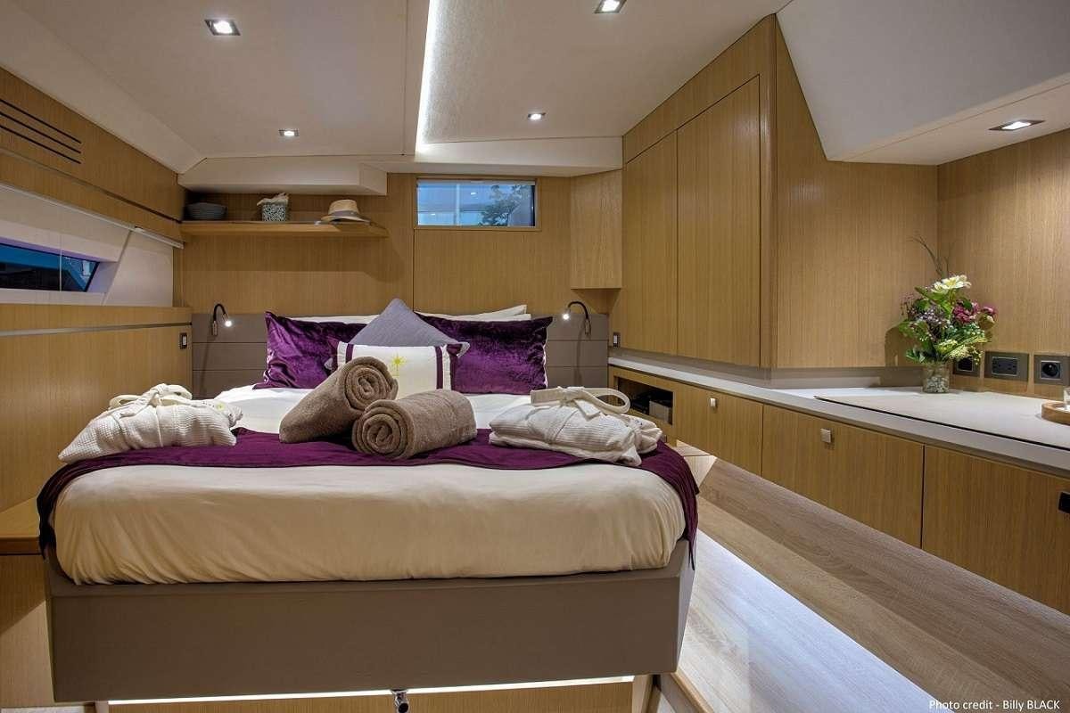 a room with a bed and a desk aboard NAMASTE Yacht for Charter