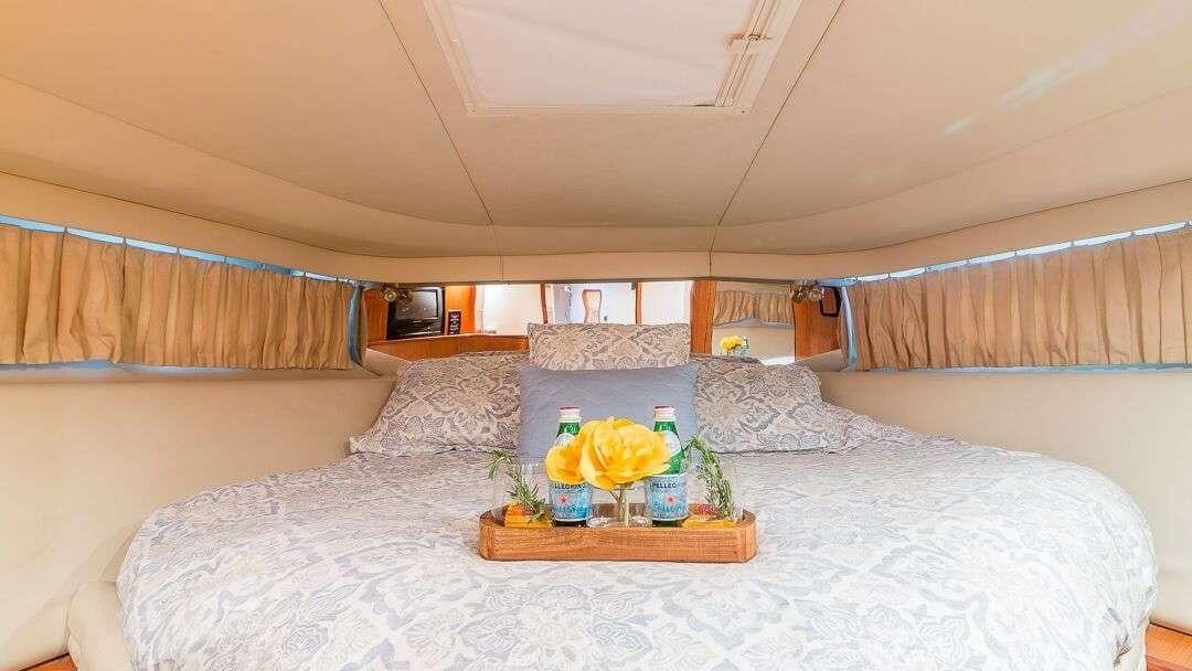 a bed with a tray of food aboard WHY NOT Yacht for Charter