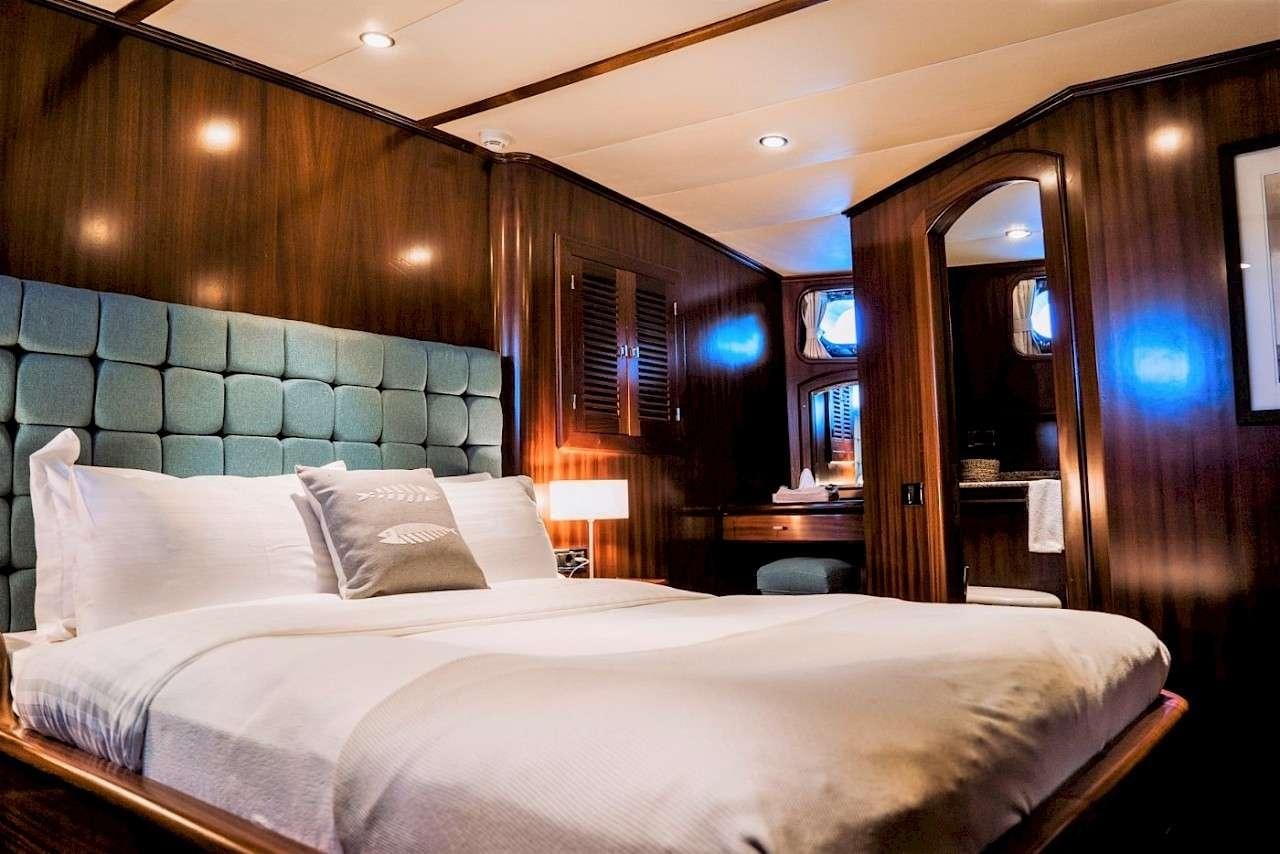 a bed with a white sheet aboard CAPRICORN 1 Yacht for Charter