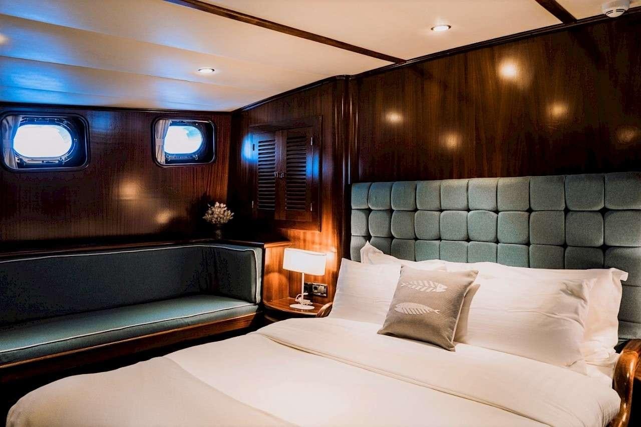 a room with a bed and a couch aboard CAPRICORN 1 Yacht for Charter