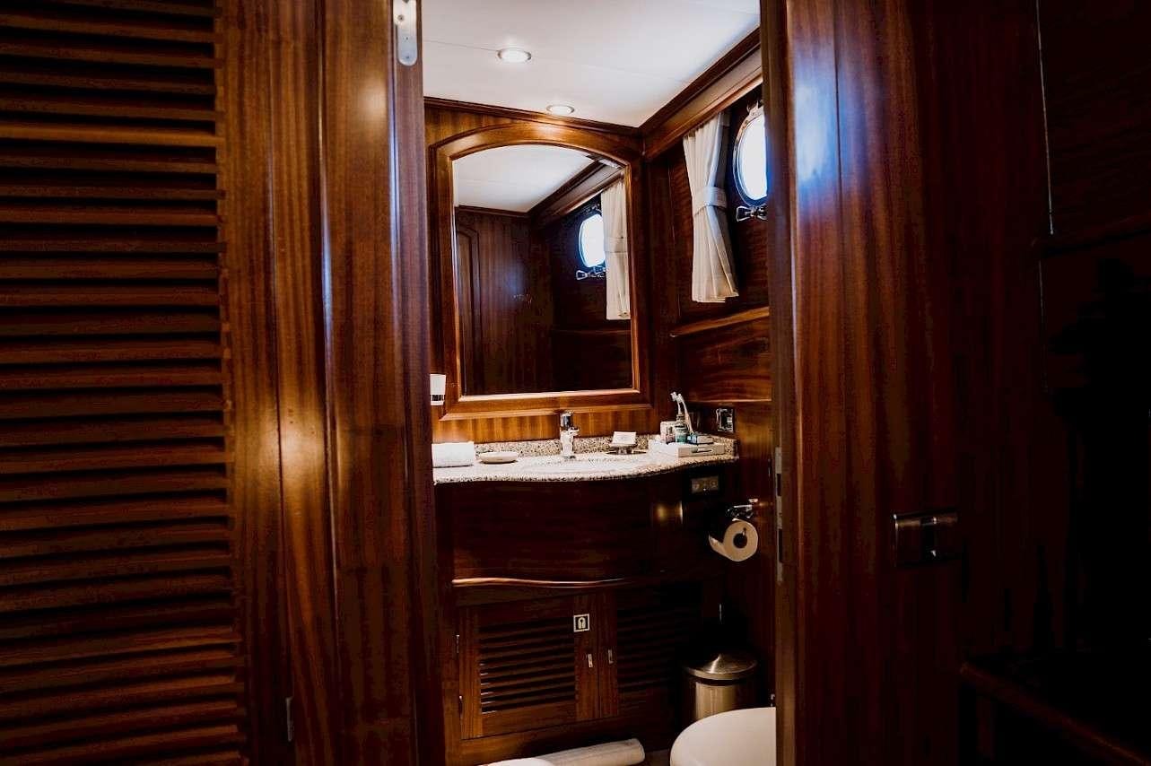 a bathroom with wood cabinets aboard CAPRICORN 1 Yacht for Charter