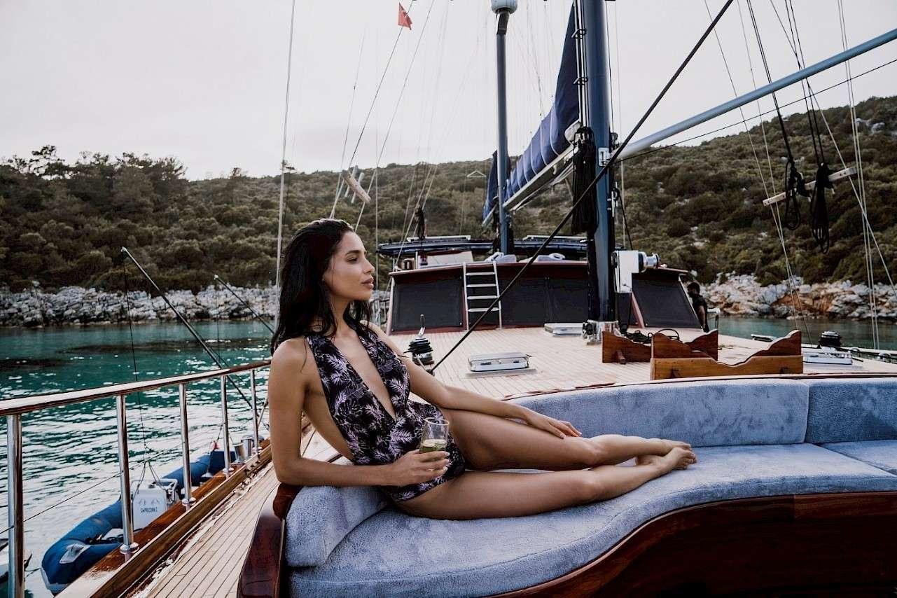 a woman sitting on a boat aboard CAPRICORN 1 Yacht for Charter