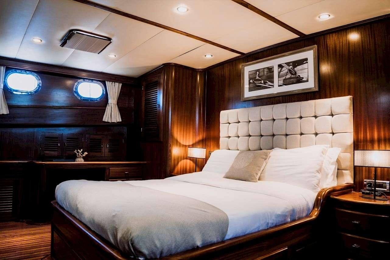 a bed with a white sheet aboard CAPRICORN 1 Yacht for Charter