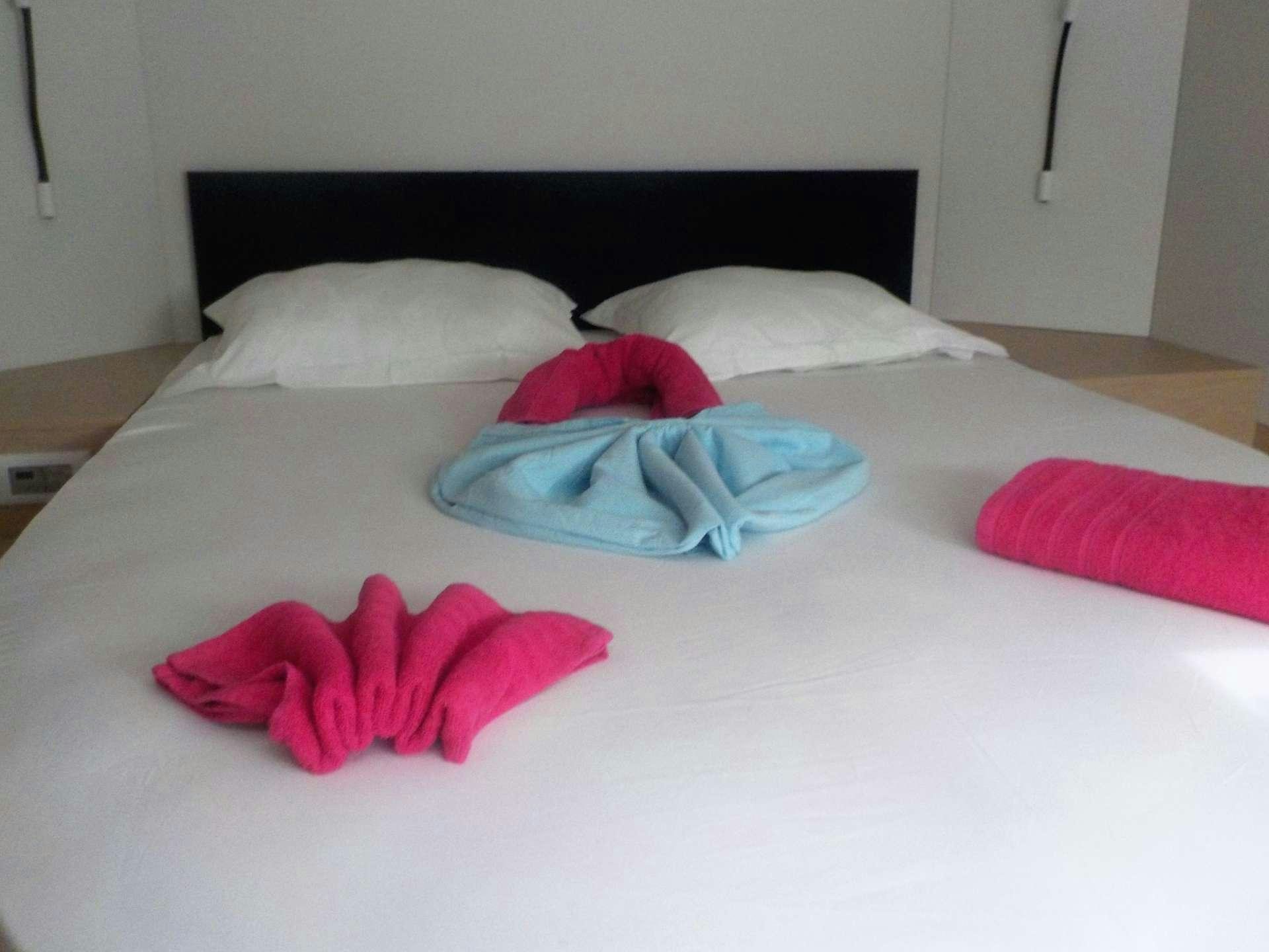 a bed with pink pillows aboard DREAM TOBAGO Yacht for Charter