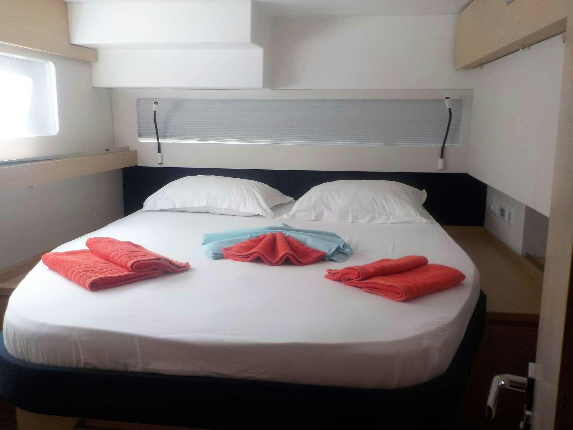 a bed with red pillows aboard DREAM TOBAGO Yacht for Charter