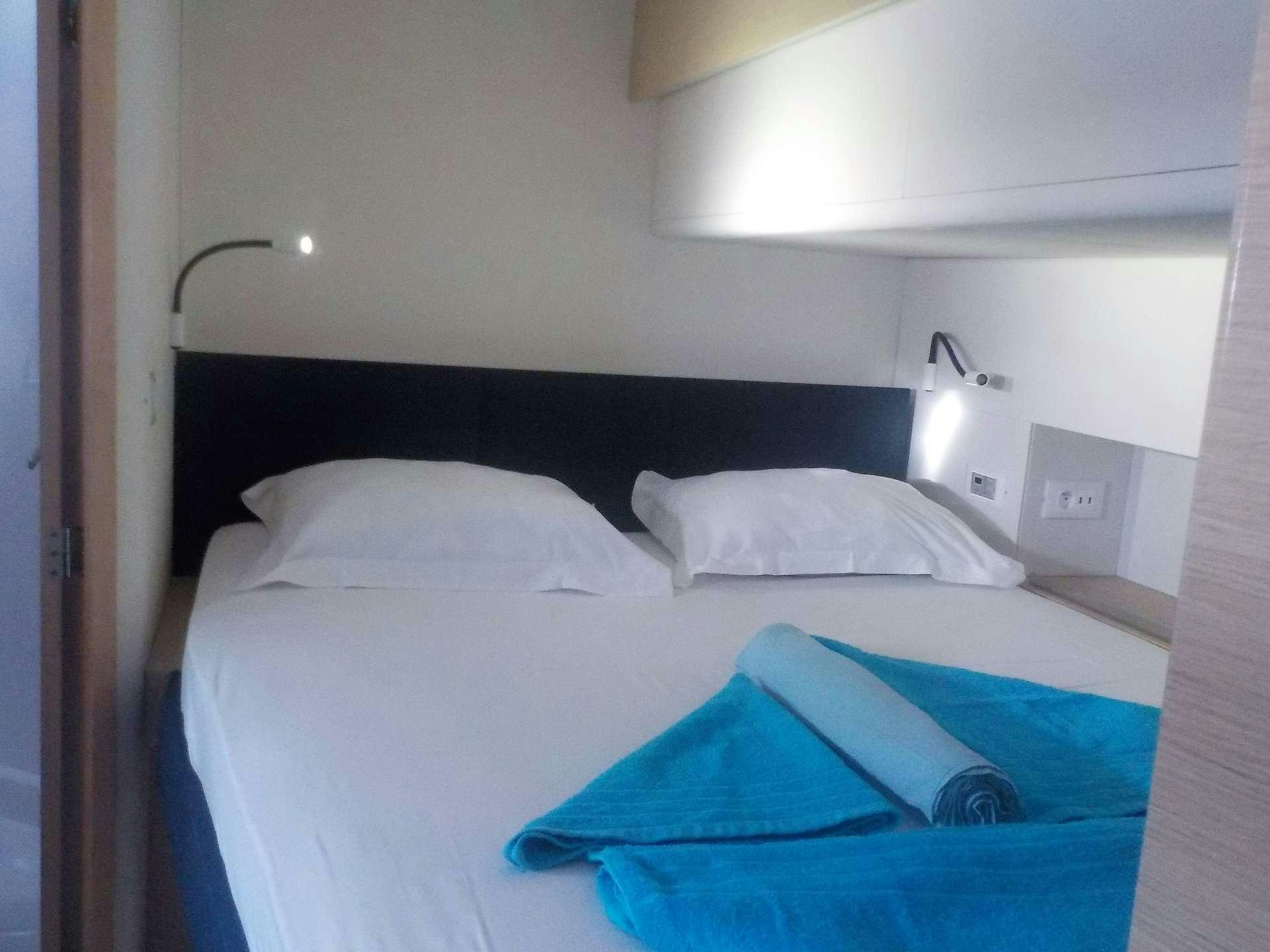 a bed with blue sheets aboard DREAM TOBAGO Yacht for Charter