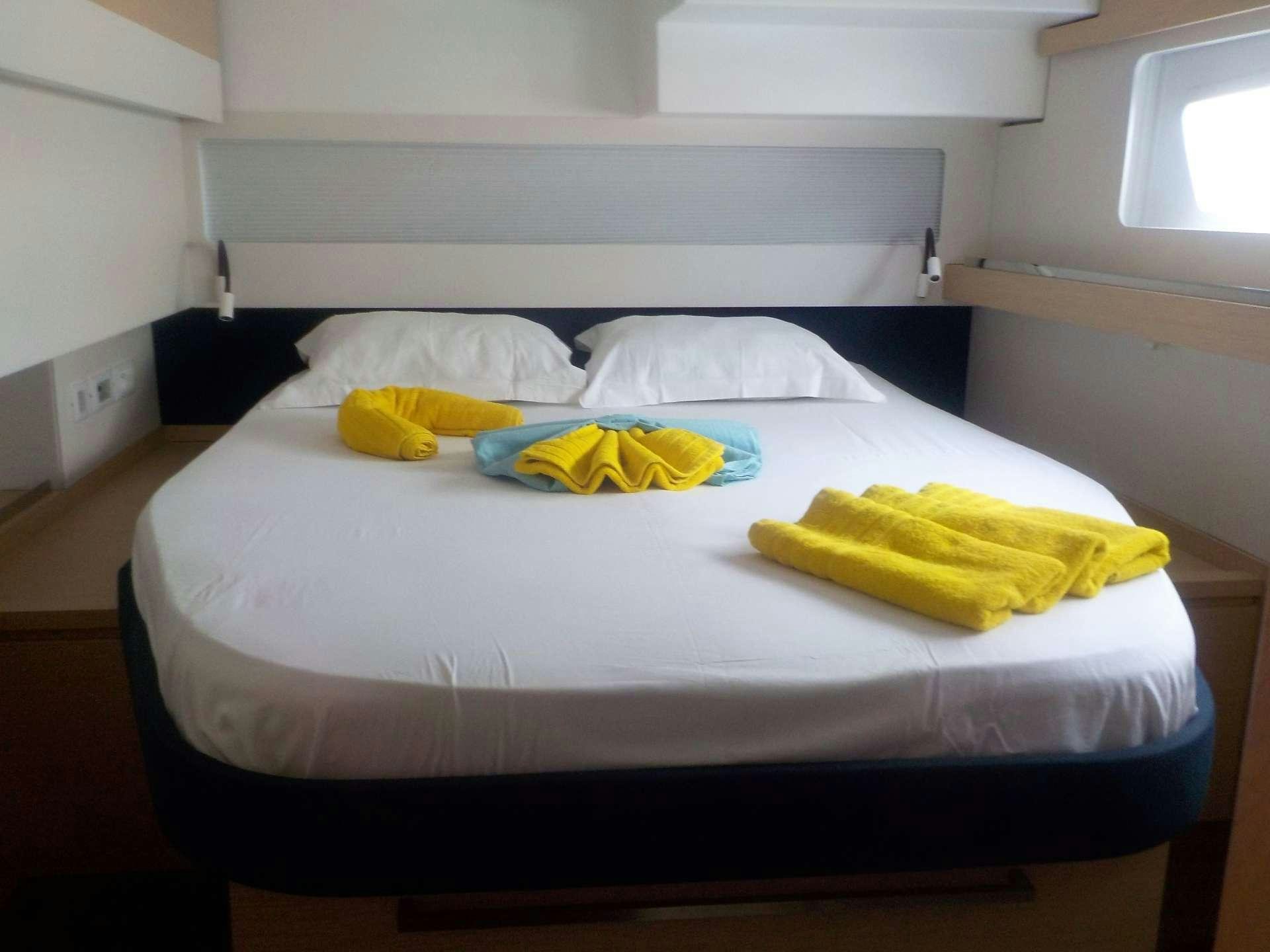 a bed with white sheets and pillows aboard DREAM TOBAGO Yacht for Charter