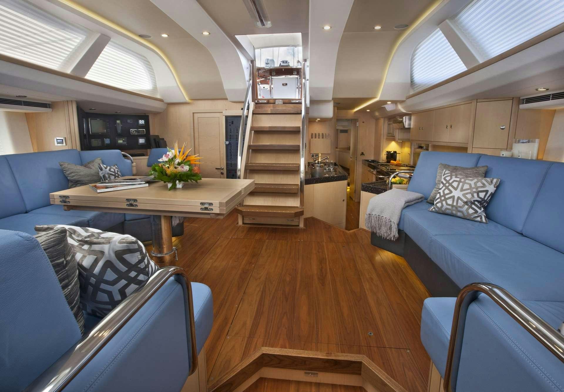 a room with a table and couches aboard LATITUDE Yacht for Charter