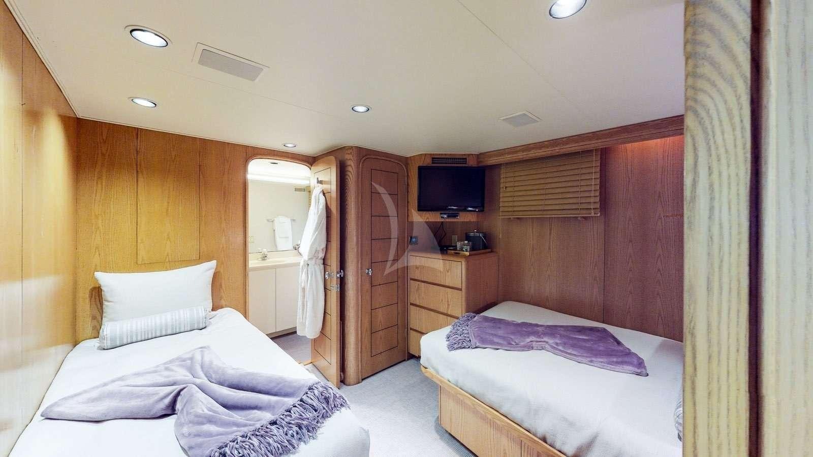 a room with a bed and a television aboard XOXO Yacht for Charter