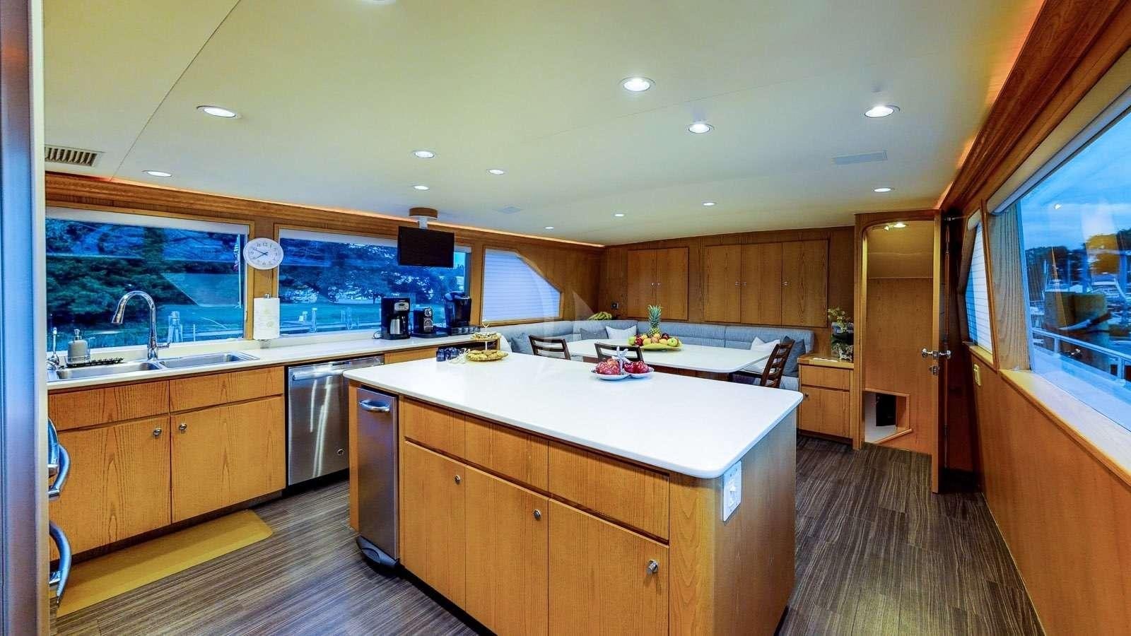 a kitchen with wooden cabinets aboard XOXO Yacht for Charter