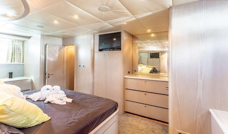 a bedroom with a bed and a television aboard PRIME TIME Yacht for Charter